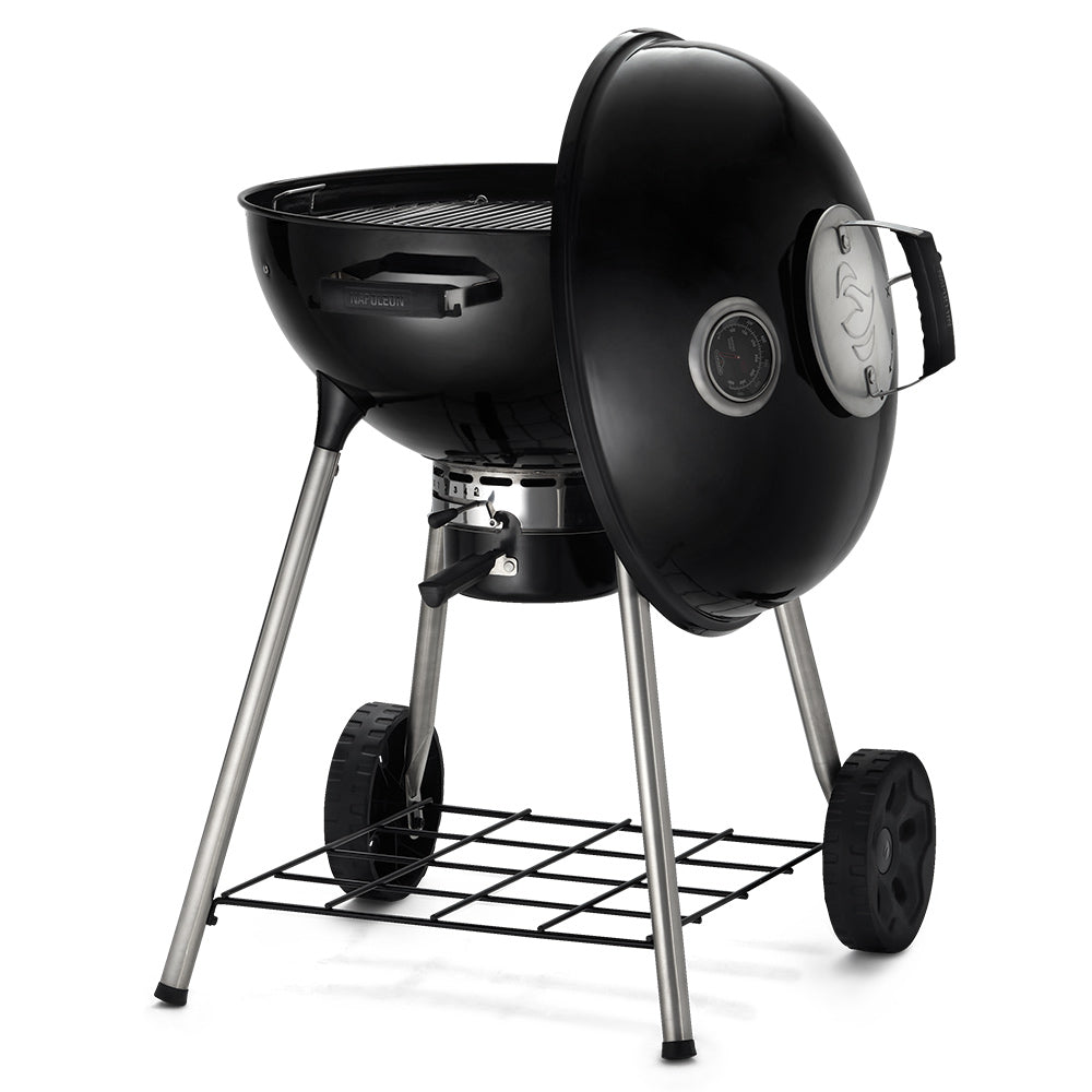 Charcoal kettle grill with open lid, ash pan, and side-mounted controls