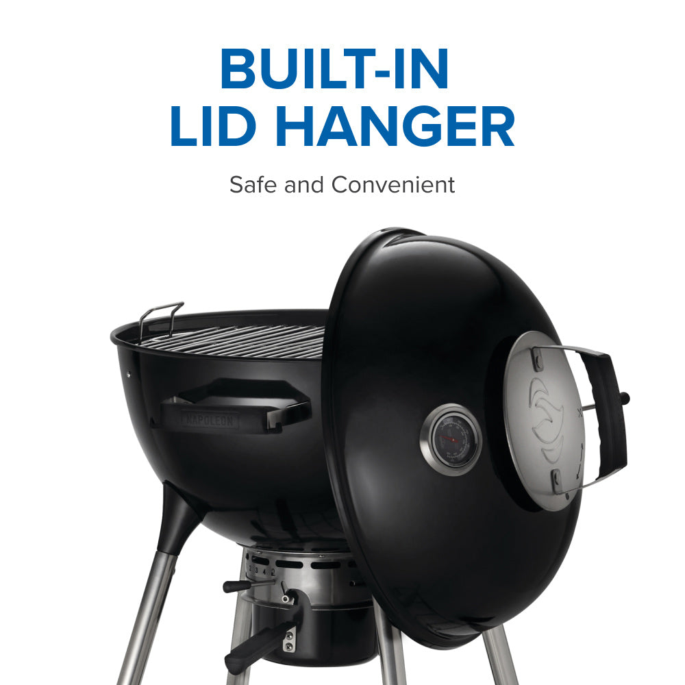 Charcoal kettle grill with built-in lid hanger and side control vent on the lid