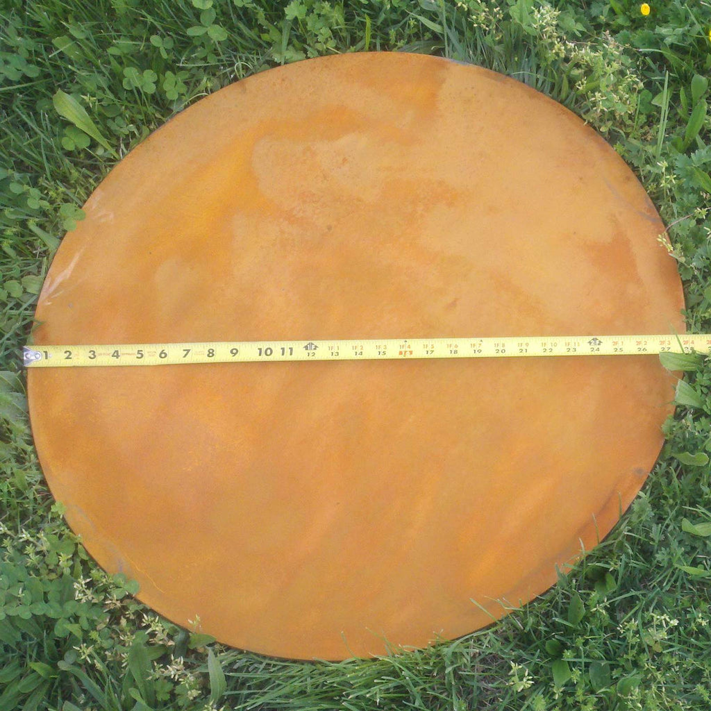 Round fire pit base plate, rust-brown metal with circular rim.