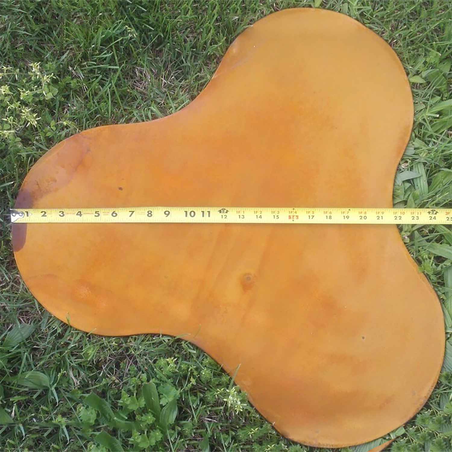 Clover-shaped fire pit base plate, orange metal with three lobes