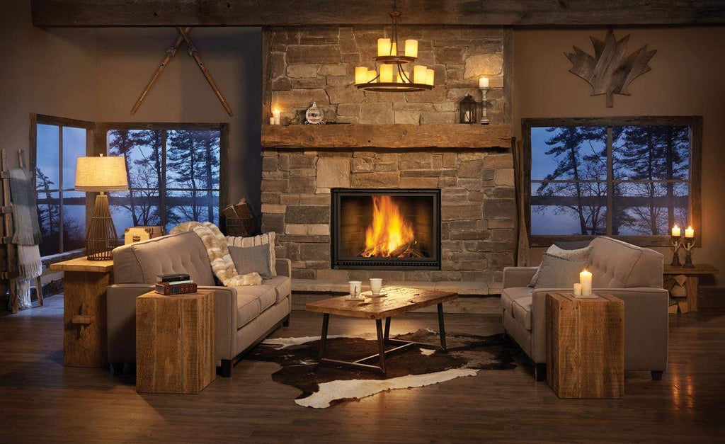 Wood fireplace with stone surround and glass front, flames over logs