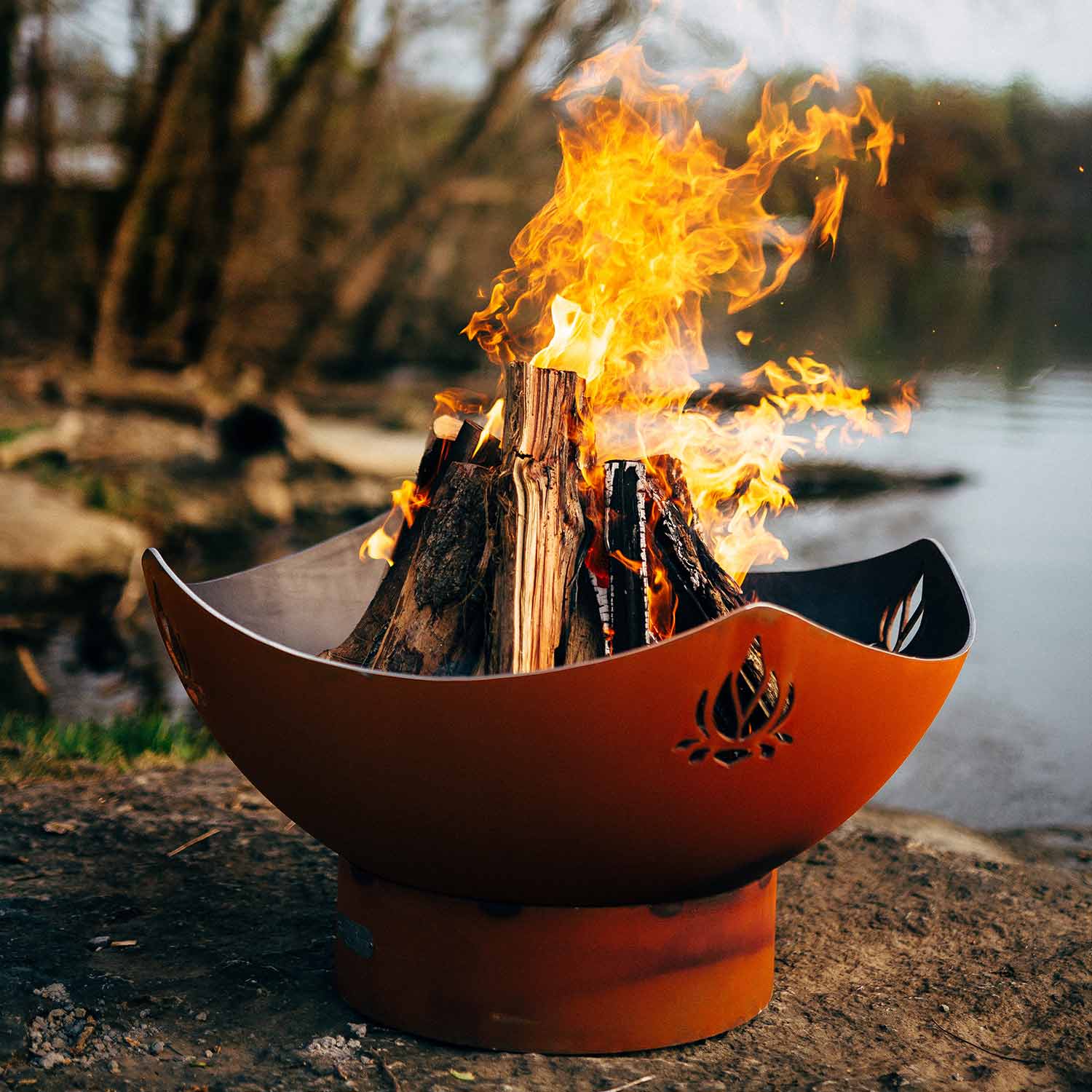Fire pit with flames burning outdoors near a body of water Fire Pit Art Namaste