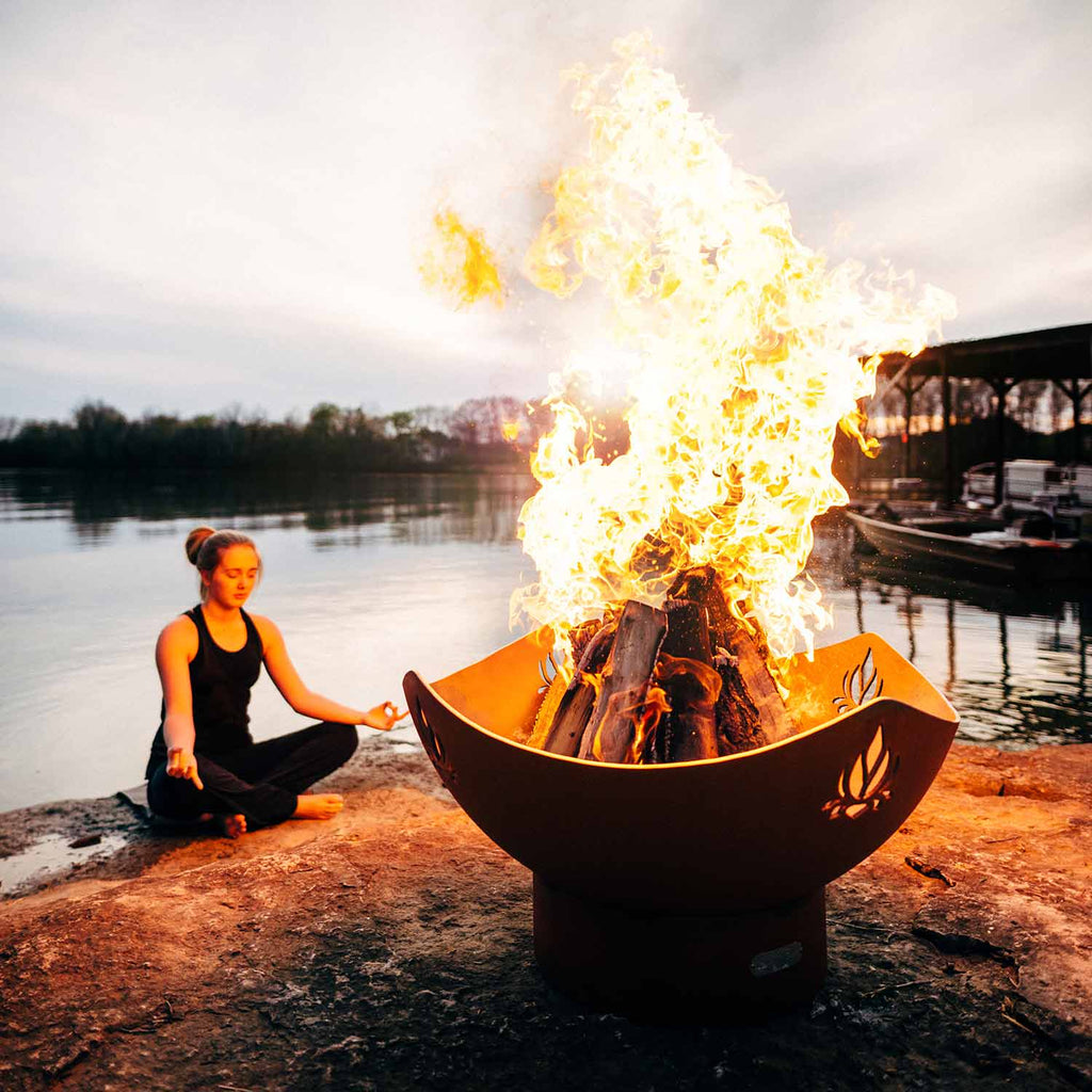 Orange steel fire pit bowl with burning flames and lotus design, open fire compartment