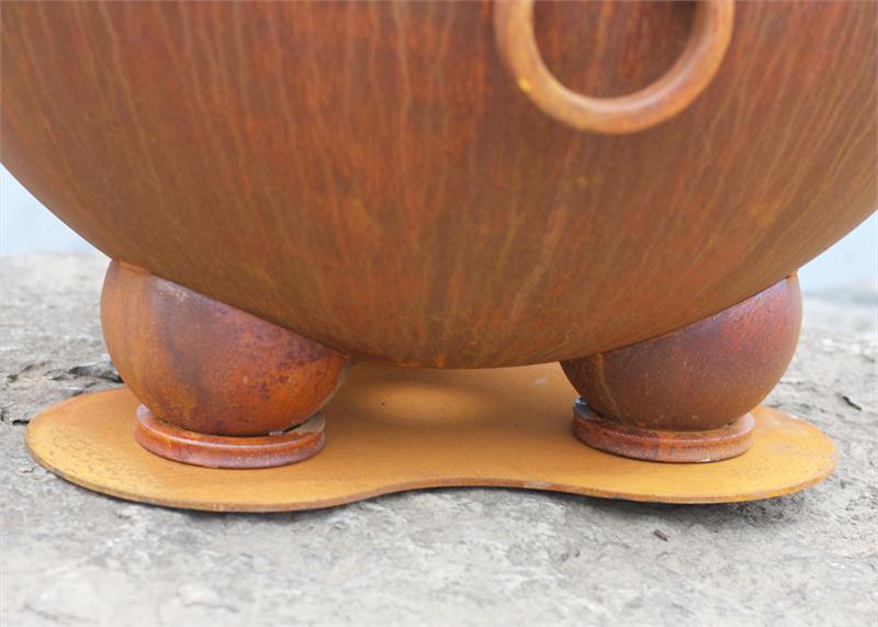 Wood fire pit base with three legs and rusted feet, copper-brown metal.