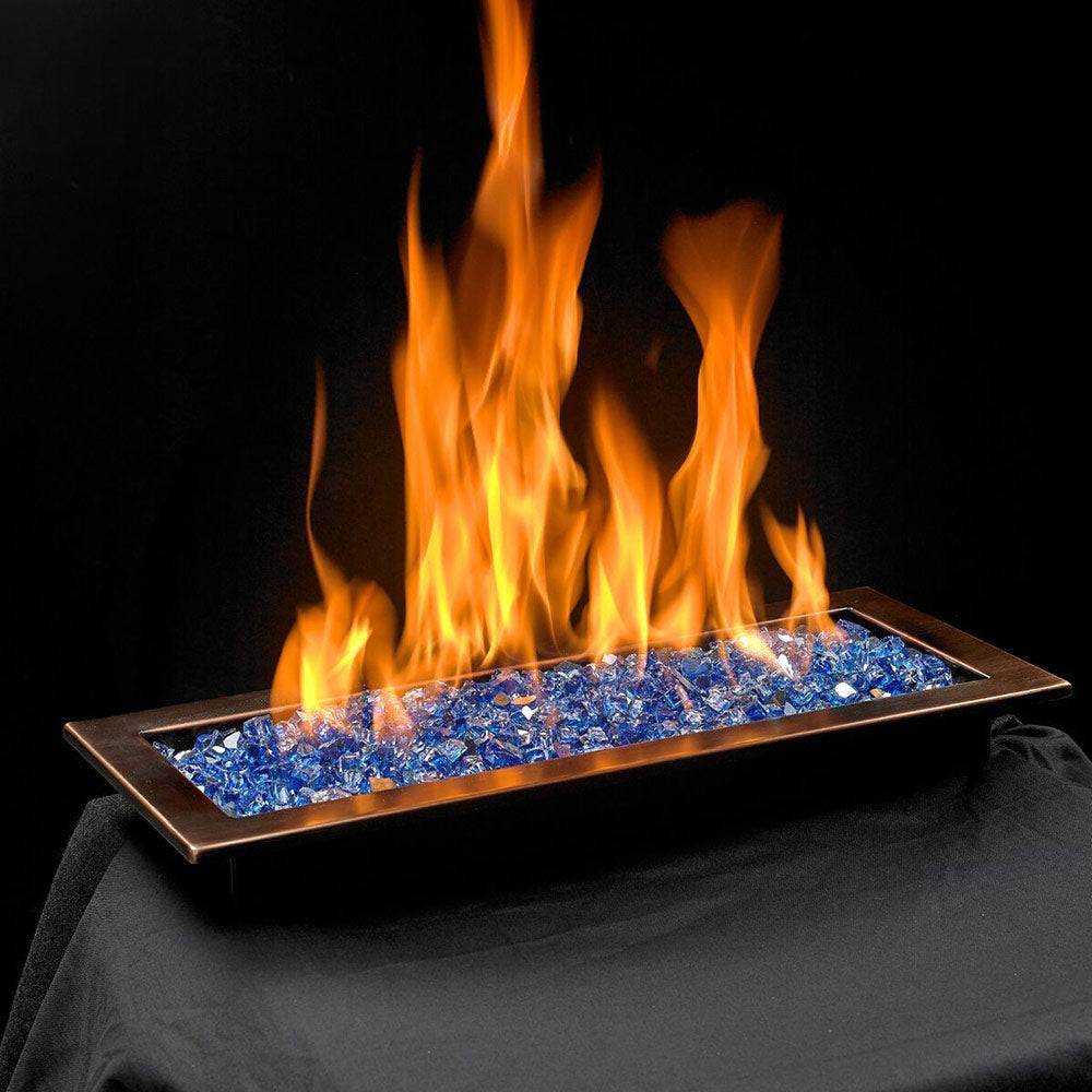 Outdoor fire pit burner with blue glass media and visible orange flames