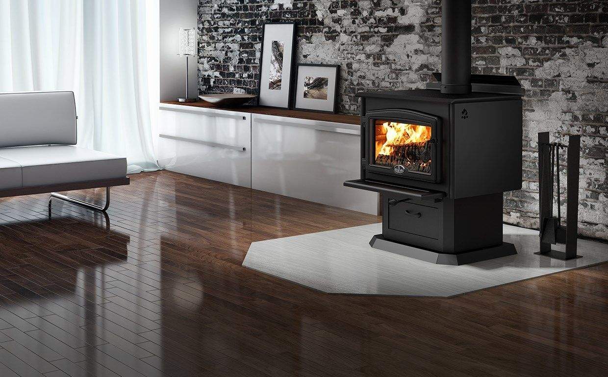 Black wood stove with glass door and burning fire, front-right view with blower pipe