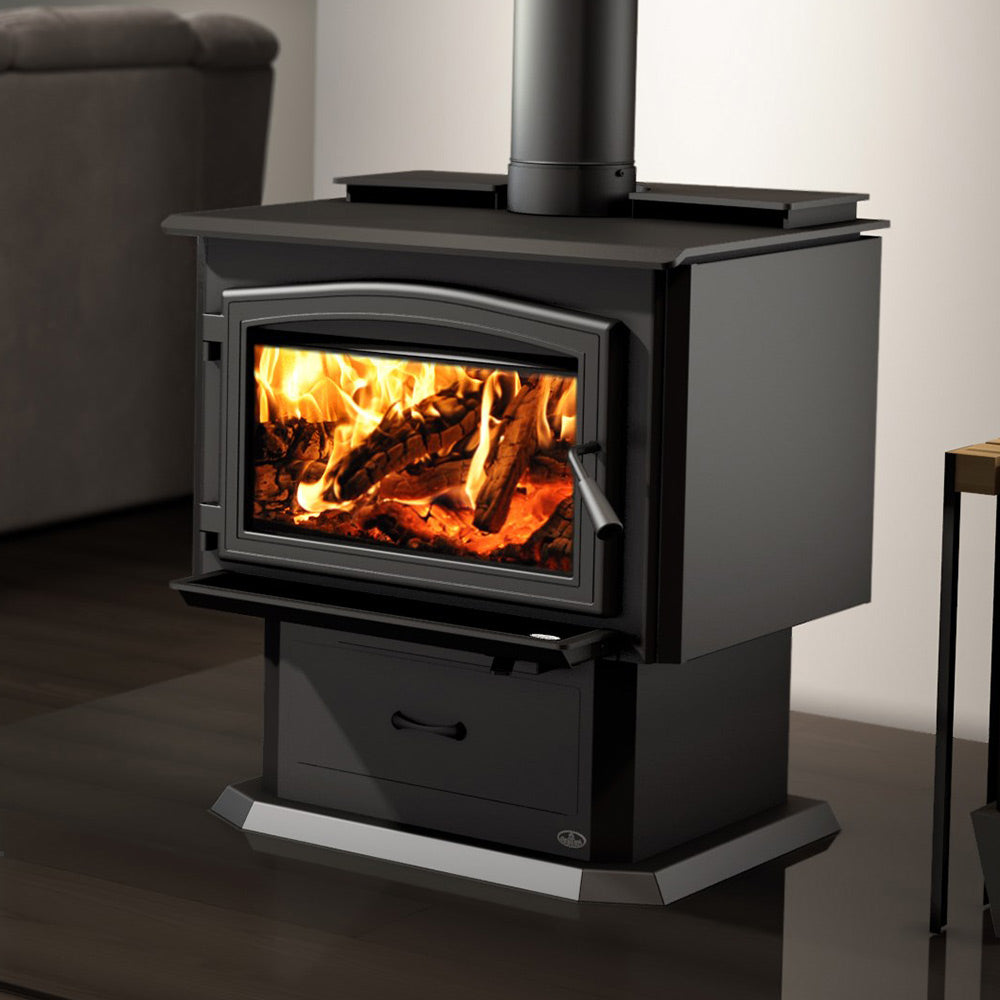 Black wood stove with glass door showing burning logs and pull-out ash drawer