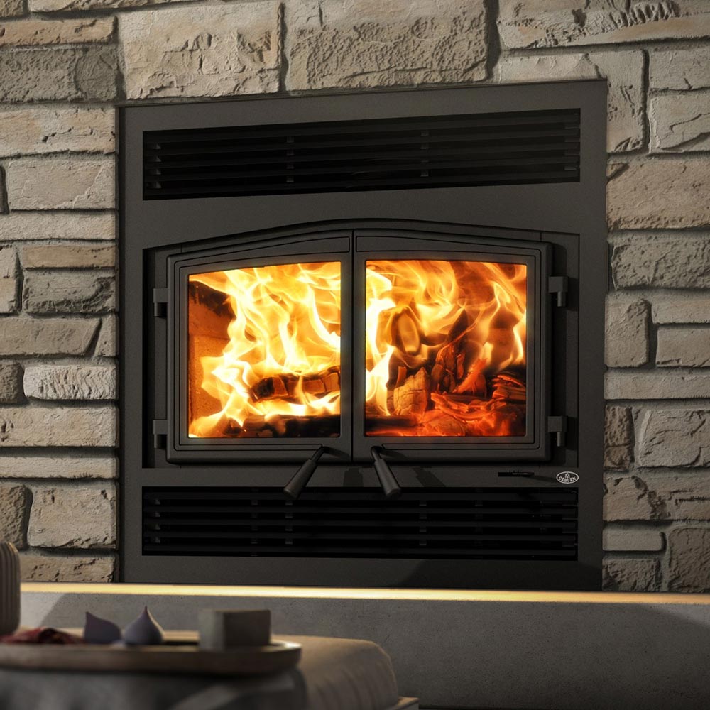 Wood fireplace with glass doors, dark gray surround, split flame view with burning logs