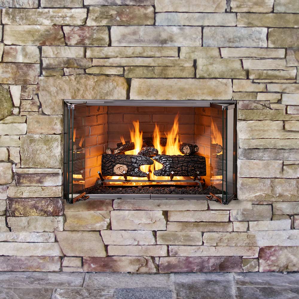 Outdoor wood-burning fireplace in stone wall surround with open door panels, burning logs