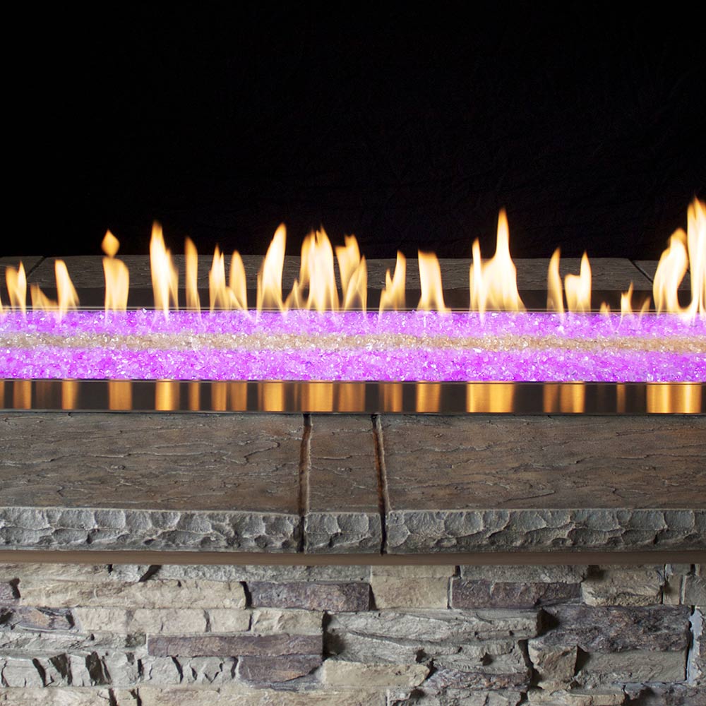 Linear gas fire pit with bronze burner, purple LED light strip, and flames