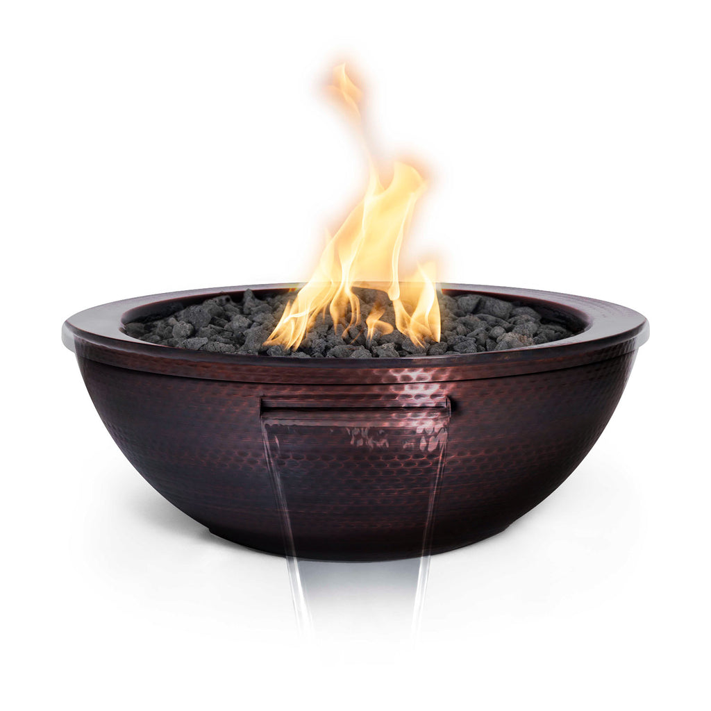 Copper gas fire and water bowl with flames above dark lava rocks