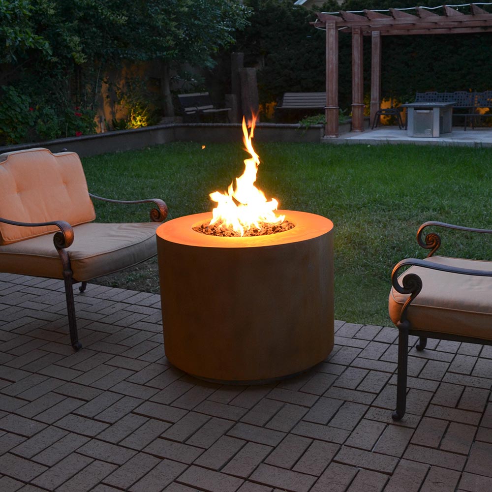 Round corten steel gas fire pit burning on patio