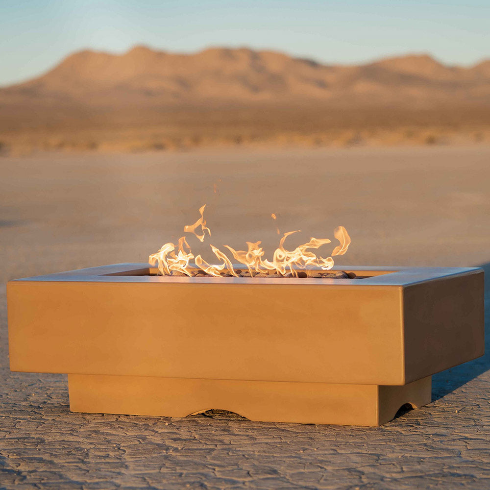 Linear concrete gas fire pit in tan with flames across the rectangular burner surface.