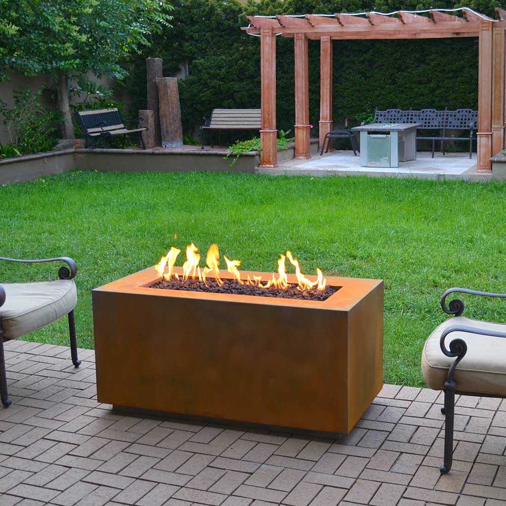 Corten steel gas fire pit on patio with flames in rectangular burner pan