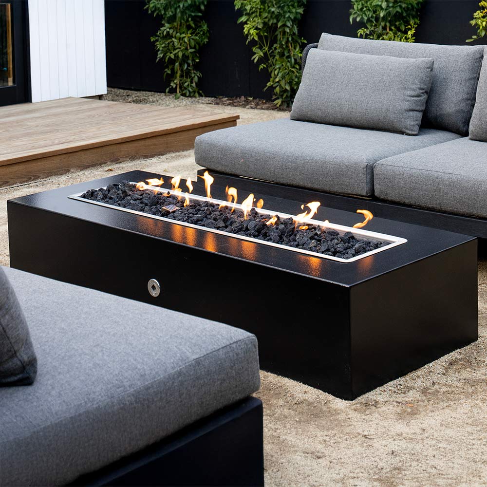 Outdoor patio with fire pit table by The Outdoor Greatroom Company and gray sofa
