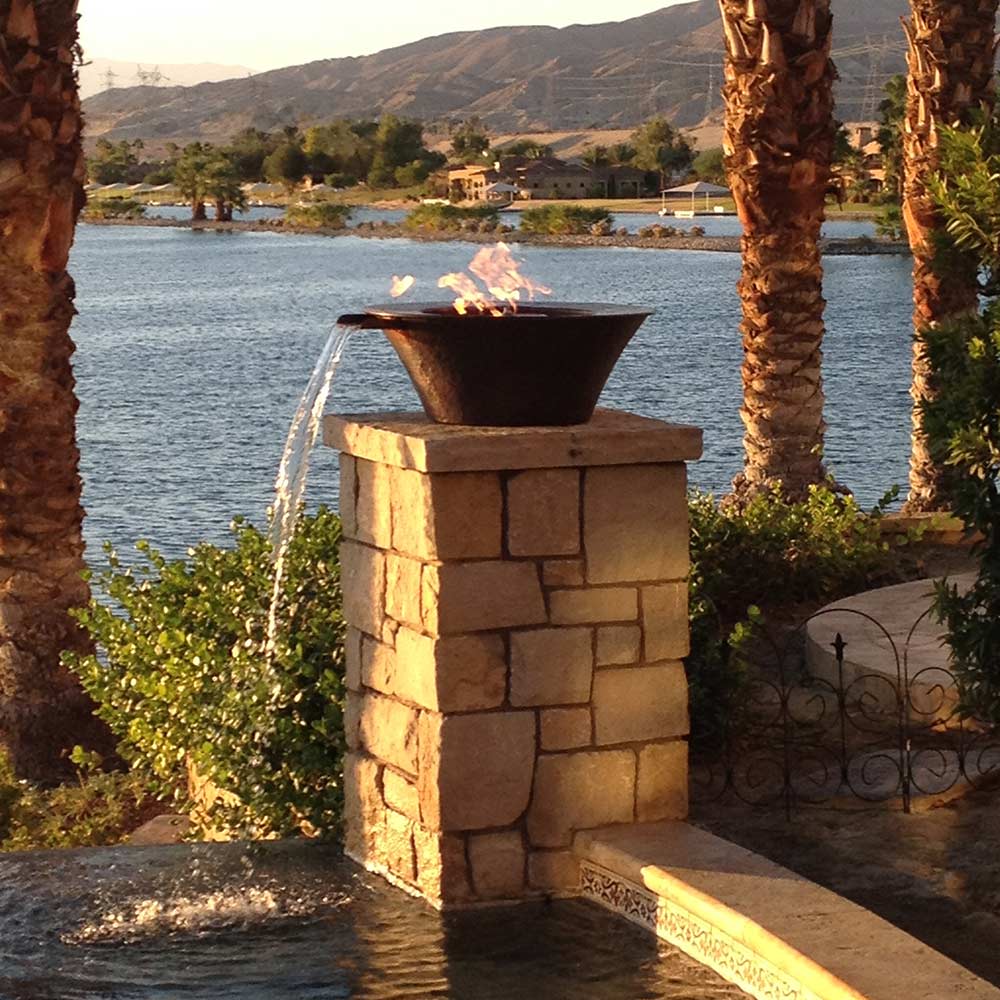 Round gas fire bowl mounted on stone pedestal, with flame and water stream below