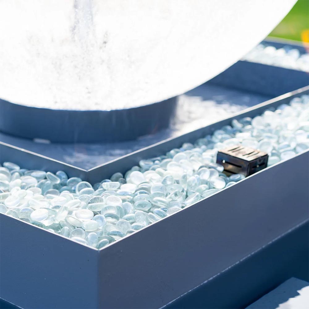 Square lower pool filled with clear water bubbles and gentle spillover into a blue basin