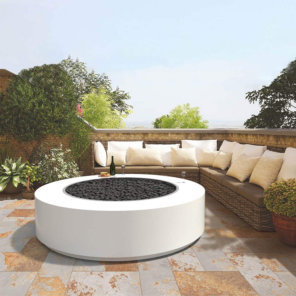 Round gas fire pit in white with flames, set on outdoor patio