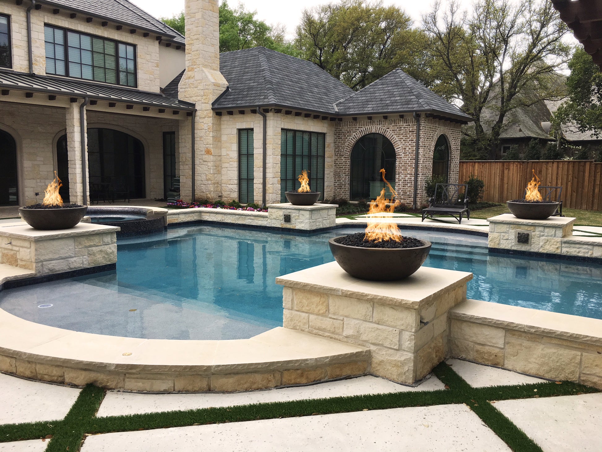 Sedona round concrete gas fire bowl with flames in a light stone finish