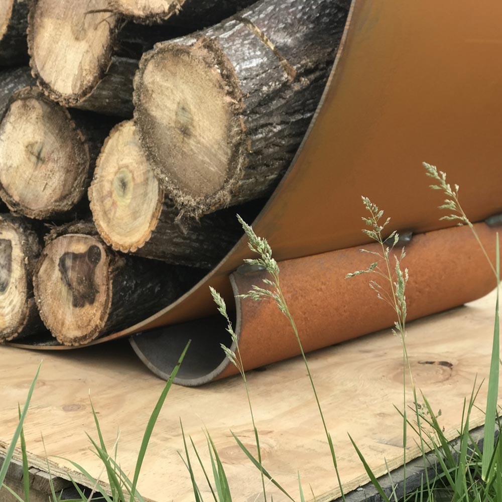 Log rack with curved orange outer shell and stacked firewood logs