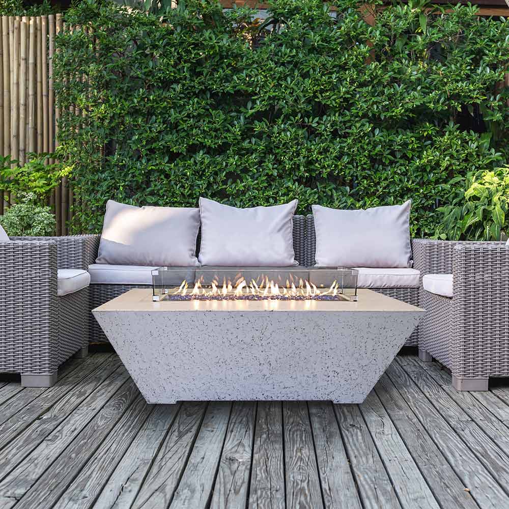 Rectangular concrete propane fire pit with gray speckled body and flames in center