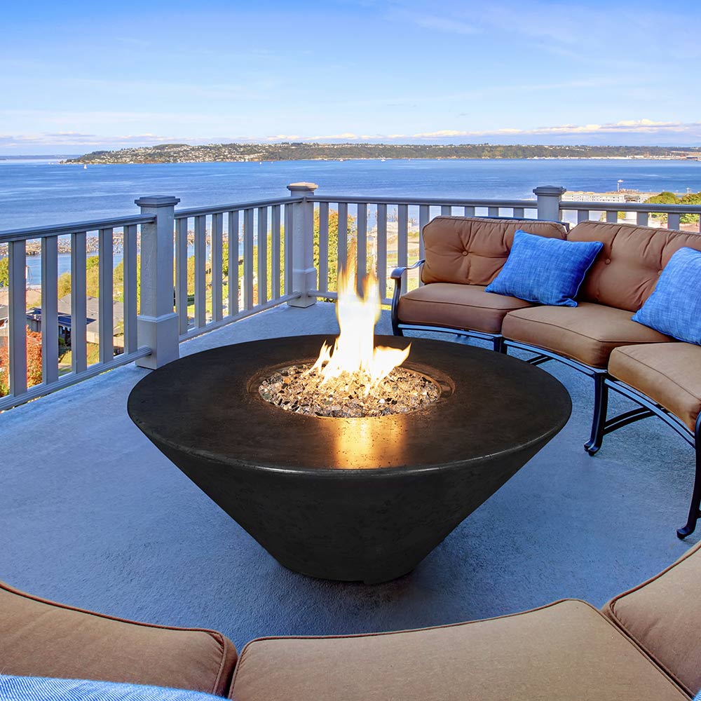 Round concrete gas fire pit with central burner pan and flame