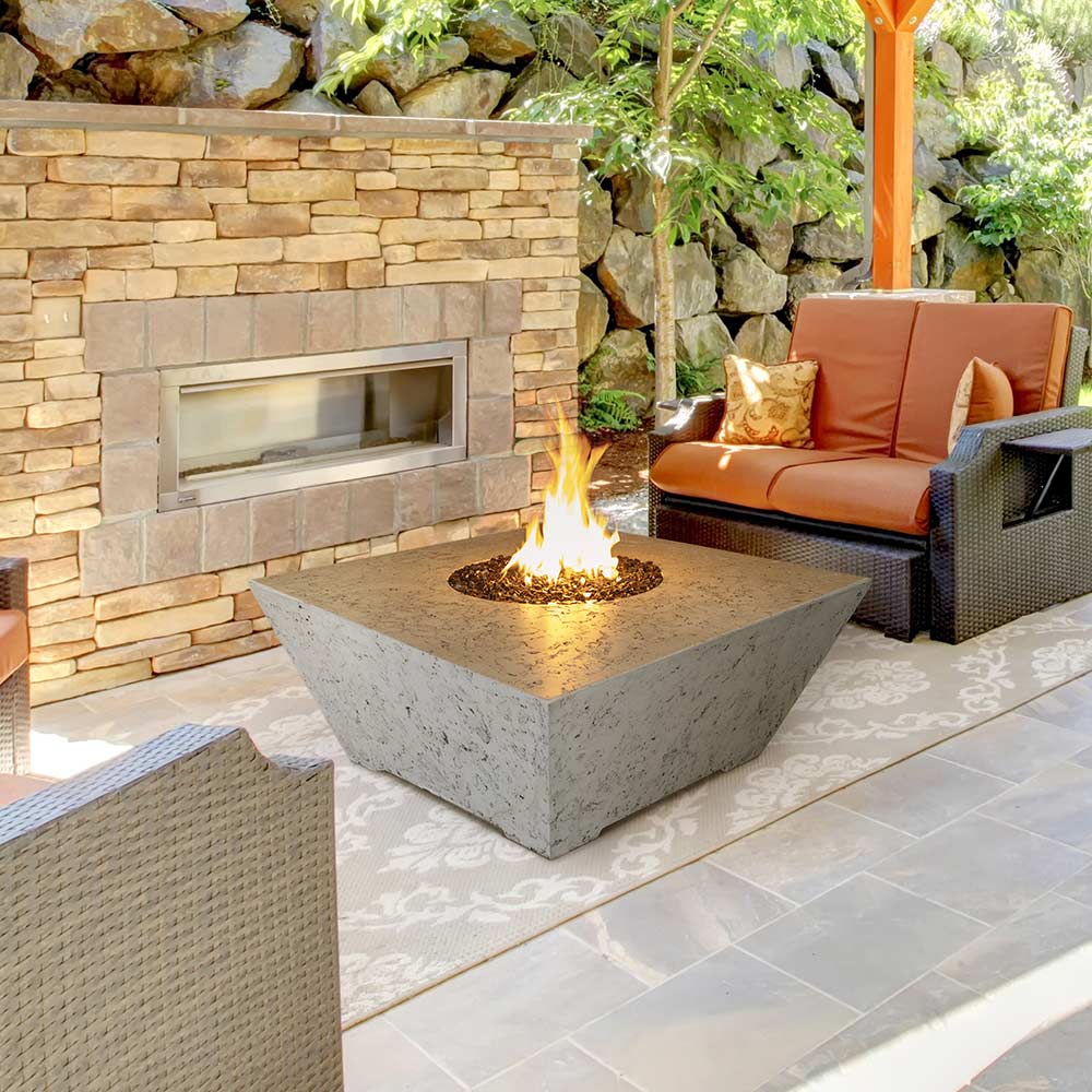 Square concrete gas fire pit with flame in center, gray stone finish
