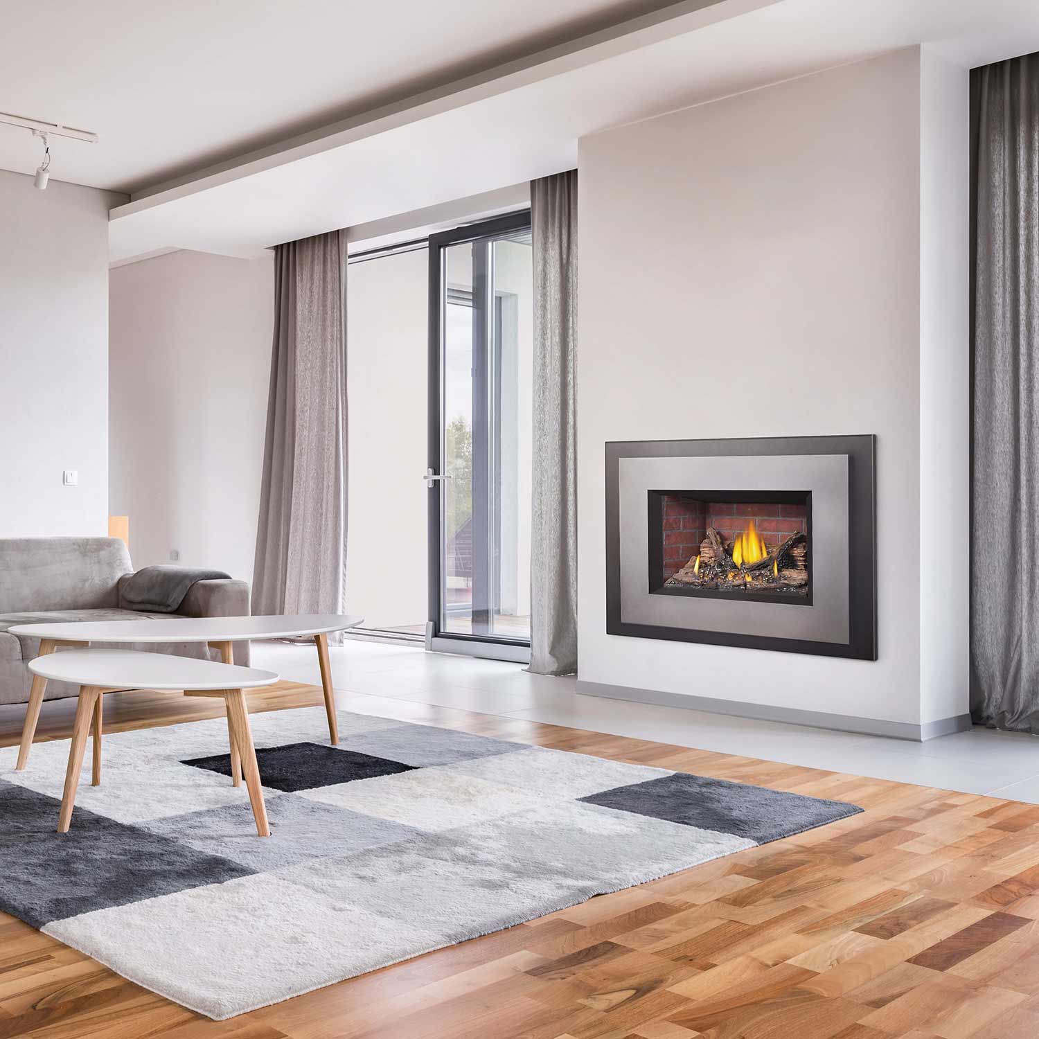 Direct vent gas fireplace insert with burning flames in wall opening, framed surround