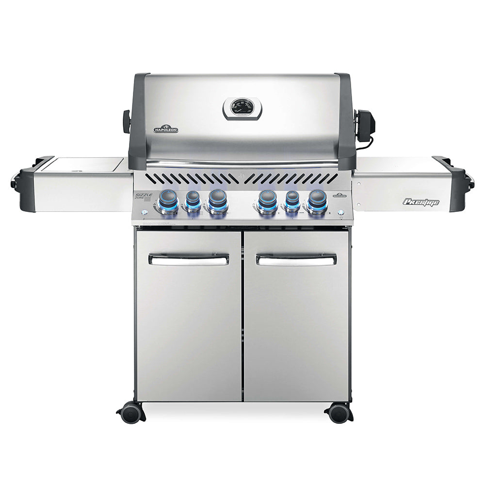 Stainless steel gas grill on cart with front control knobs, side shelves, and two doors