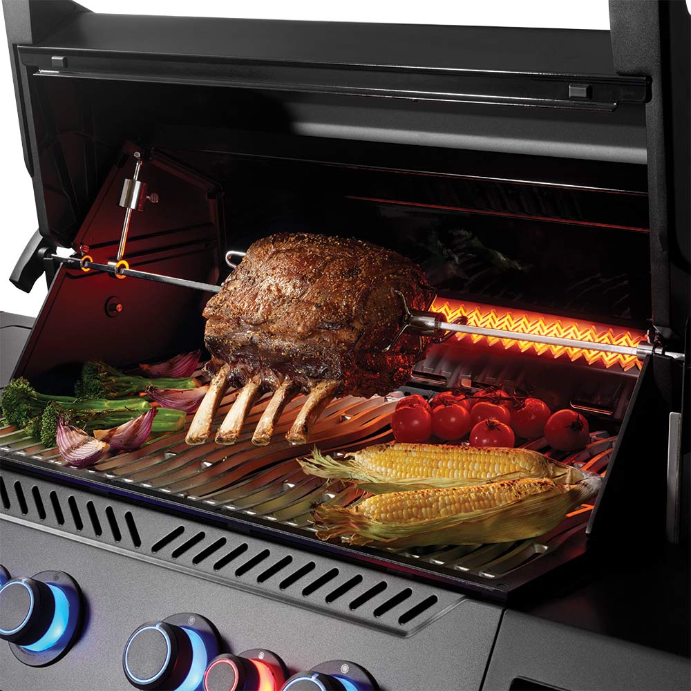 Open grill with cooked meat, corn, and vegetables on stainless grates