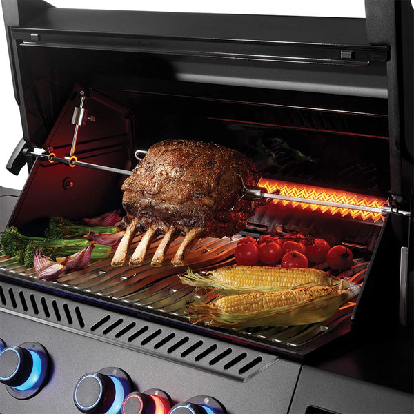 Open grill with cooked meat, corn, and vegetables on stainless grates