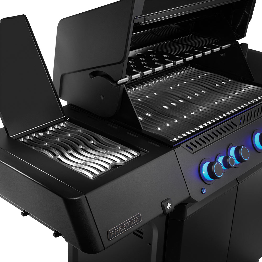 Open black gas grill showing stainless grates and blue-lit control knobs