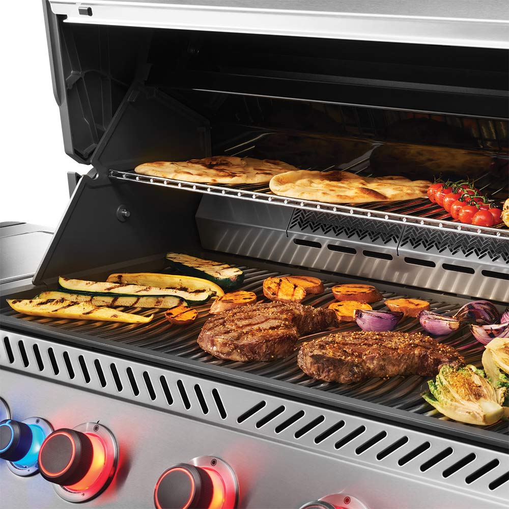 Open gas grill with burgers, vegetables, and hot cooking grates with visible heat