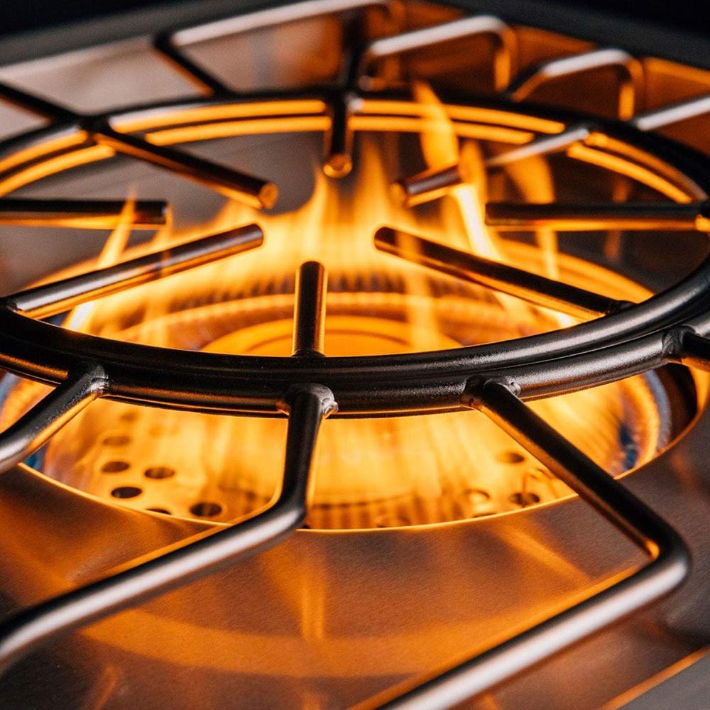 Gas burner grate with visible flames over a stainless burner ring