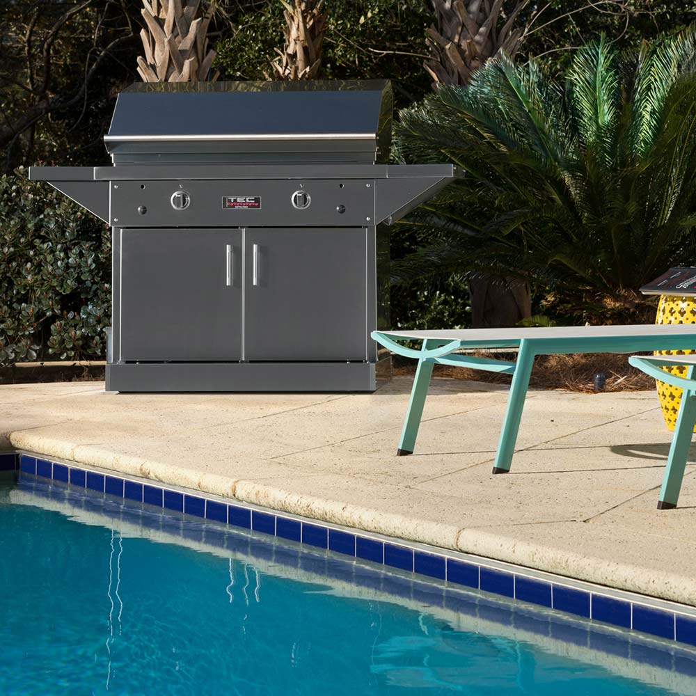 Freestanding infrared gas grill on cabinet pedestal base, viewed outdoors
