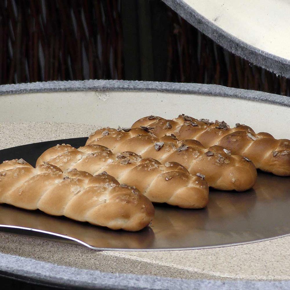 Oval baking stone with baguette-style bread rolls on top