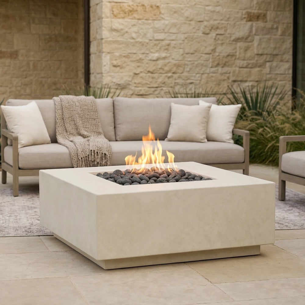 Light beige concrete gas fire pit with visible flame and black rock burner bed.