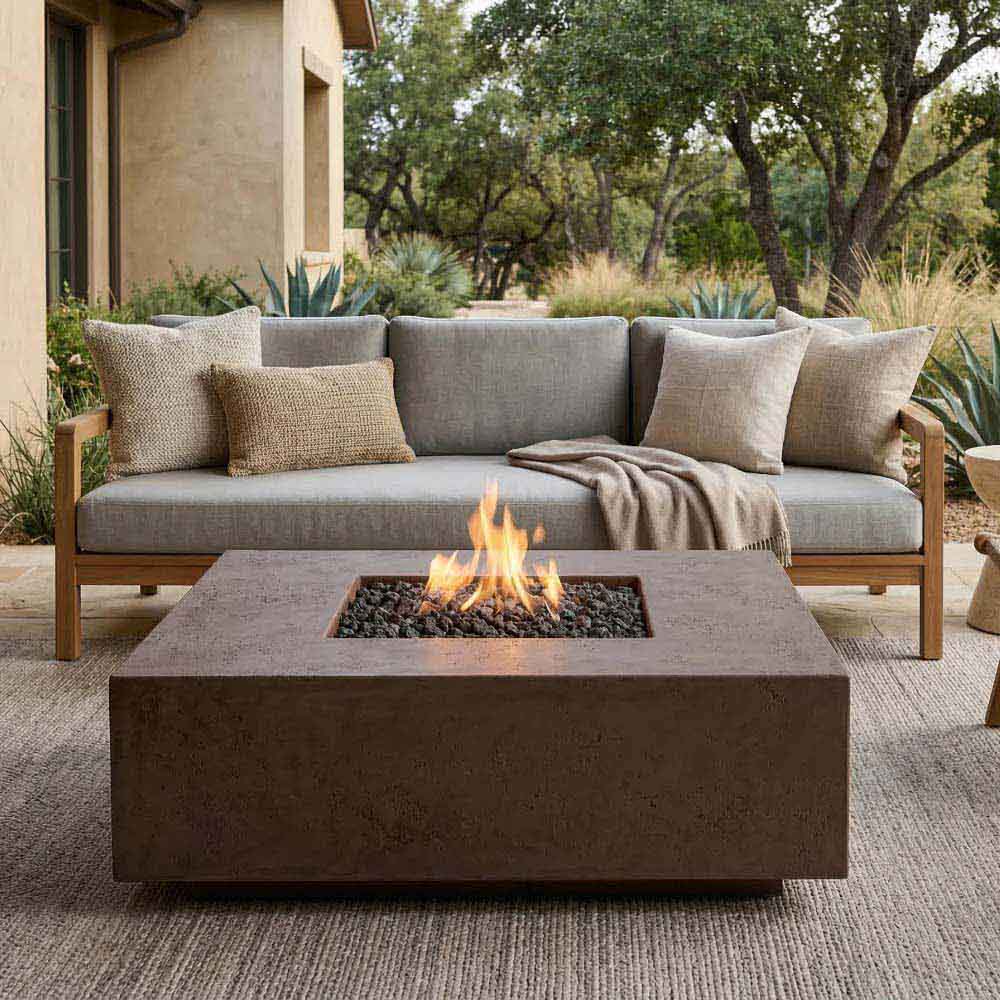 Square concrete gas fire pit with flames over black lava rocks on burner tray