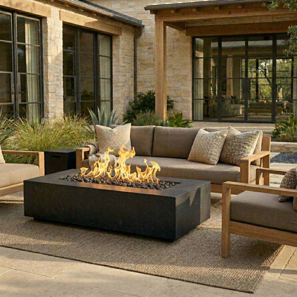 Rectangular concrete gas fire pit with visible flames on outdoor patio