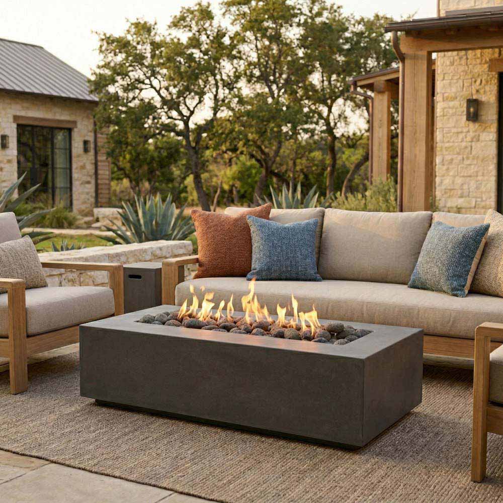 Concrete rectangular gas fire pit with flames on outdoor patio