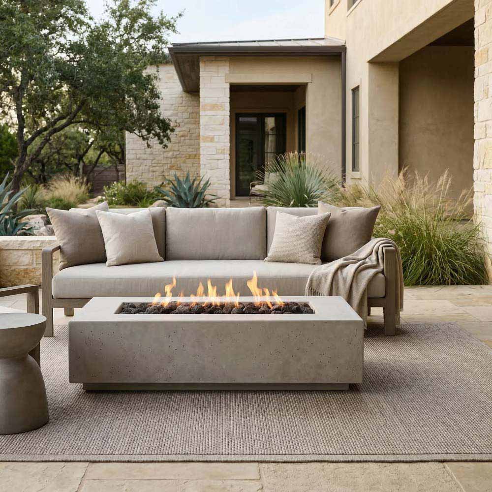 Gray concrete gas fire pit with rectangular firebox and visible flames