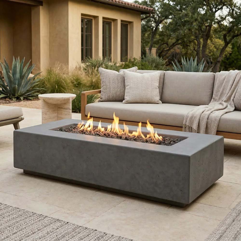 Gray concrete gas fire pit with rectangular frame and burning flames