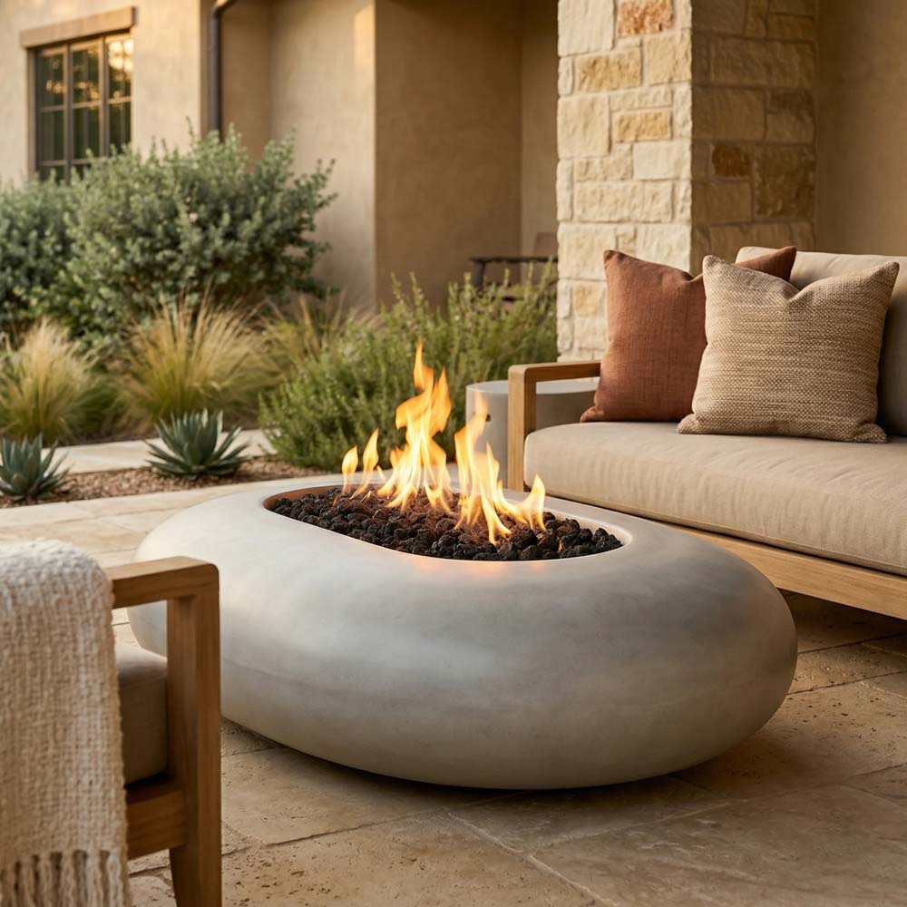 Pebble concrete gas fire pit with flame, rounded bowl shape, on outdoor patio