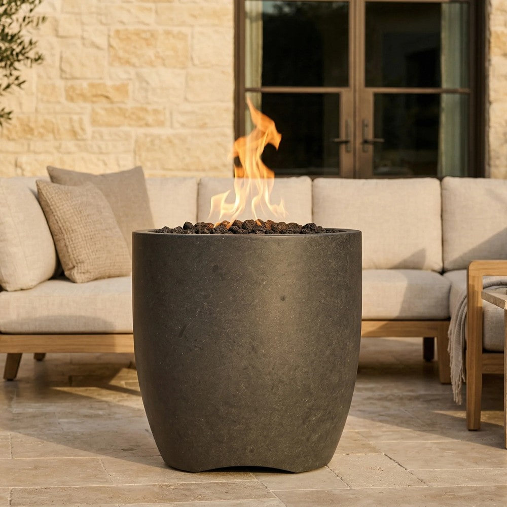Concrete gas fire pit with flames, dark gray bowl in outdoor seating area