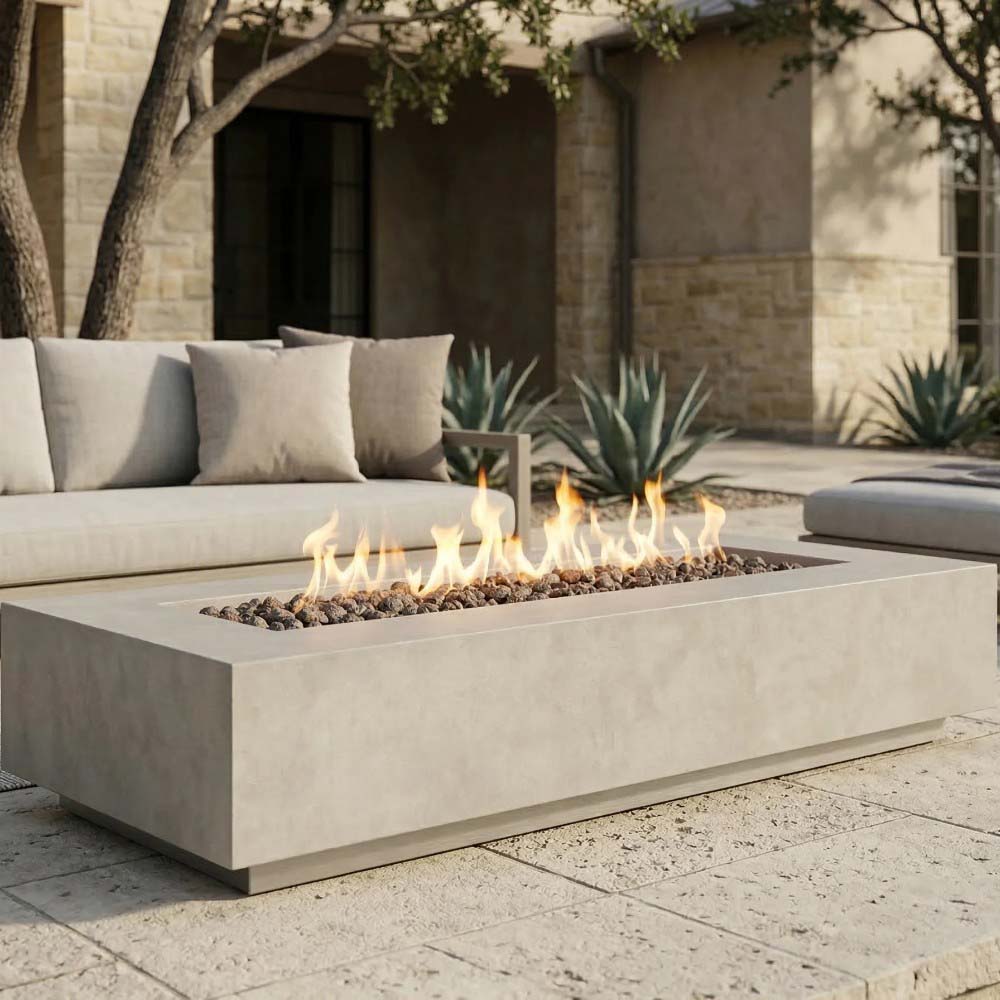 Rectangular concrete gas fire pit with open flame and dark fire media