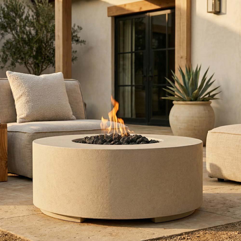 Light beige round concrete gas fire pit with lit burner and flame