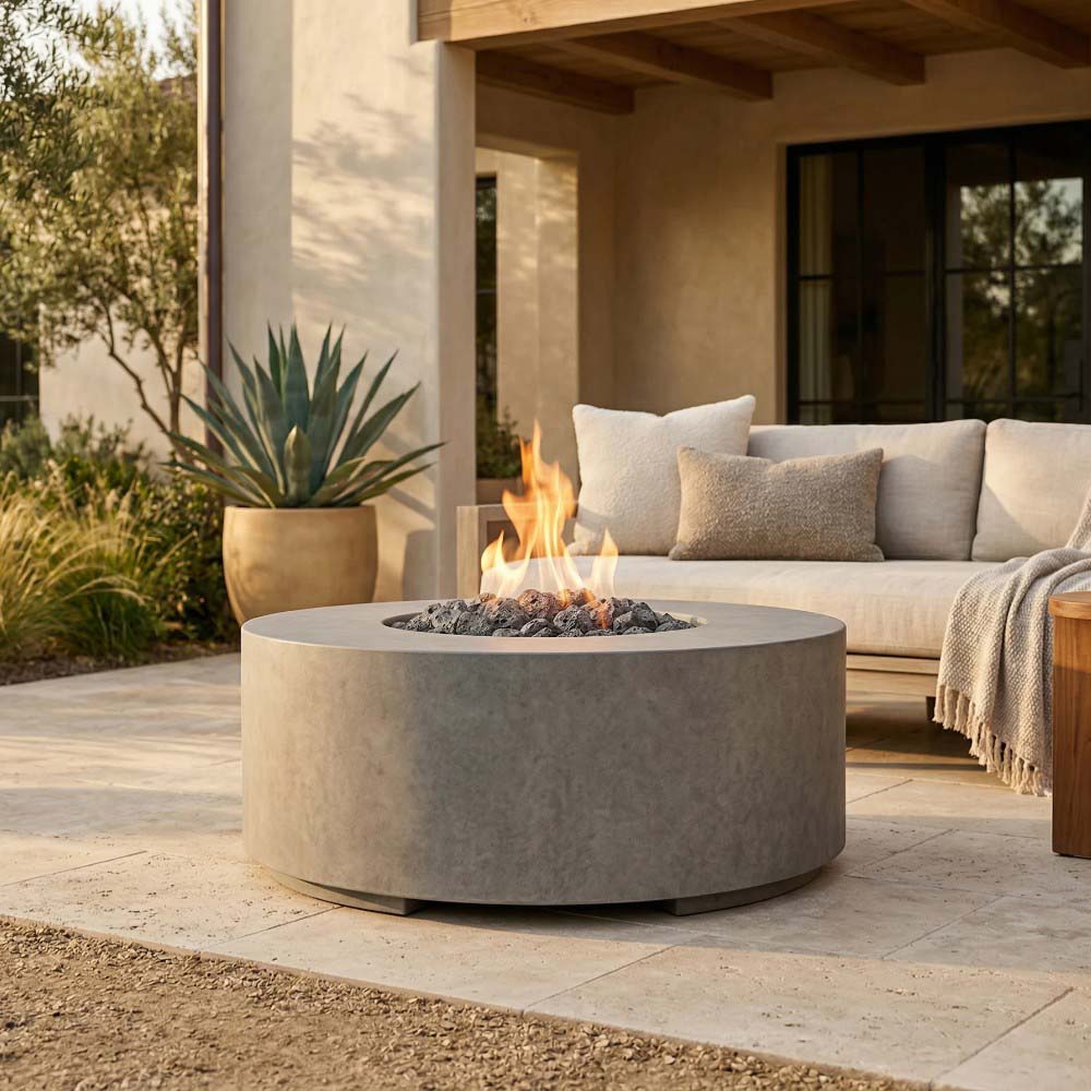 Sand-colored round concrete gas fire pit with lit burner and flame