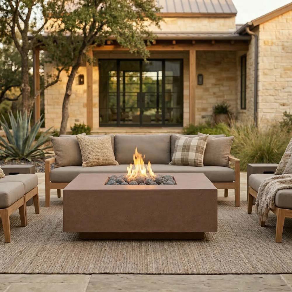 Square concrete gas fire pit with flames, burner bed filled with dark lava rocks