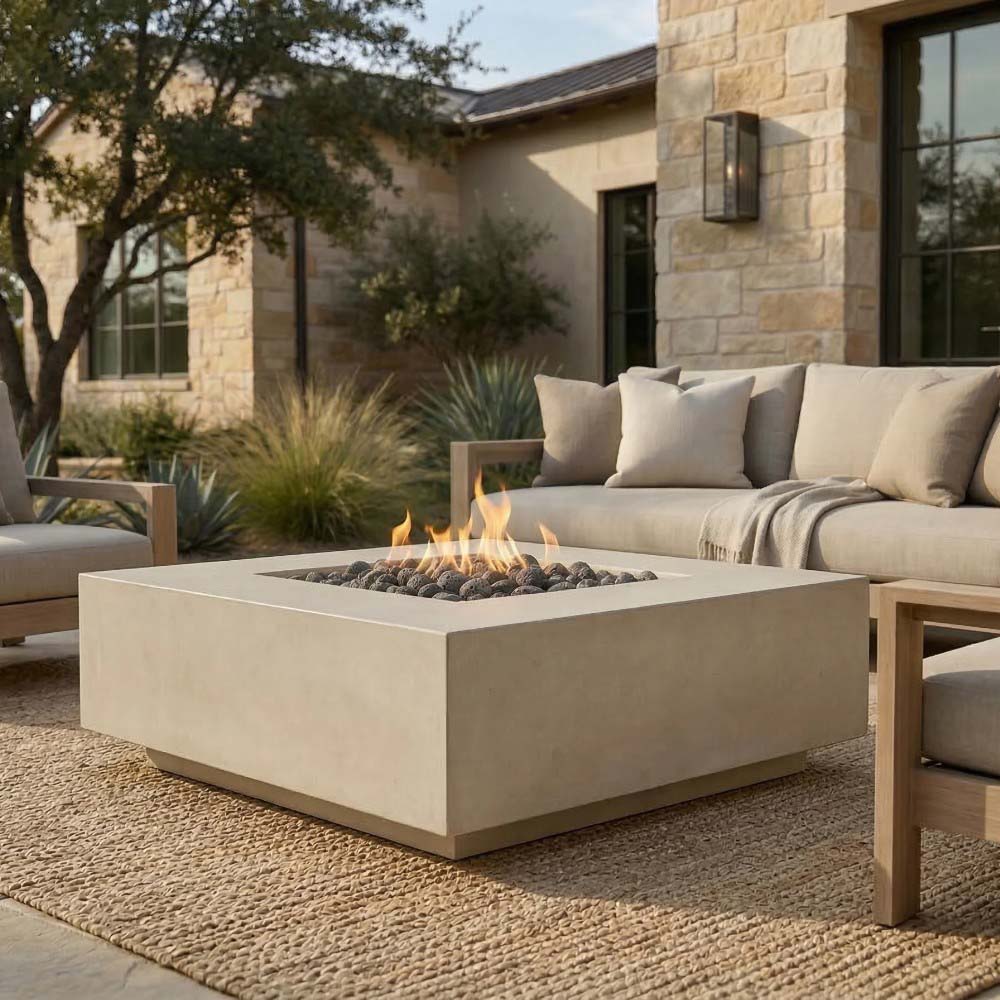 Square concrete gas fire pit with visible flame and dark lava rocks in burner pan