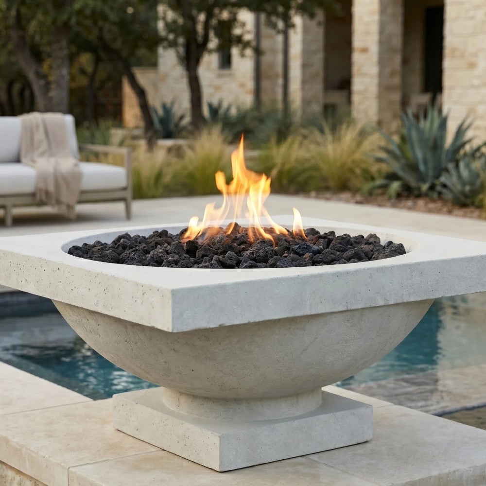 Concrete gas fire bowl with visible flames and lava rocks in a round basin